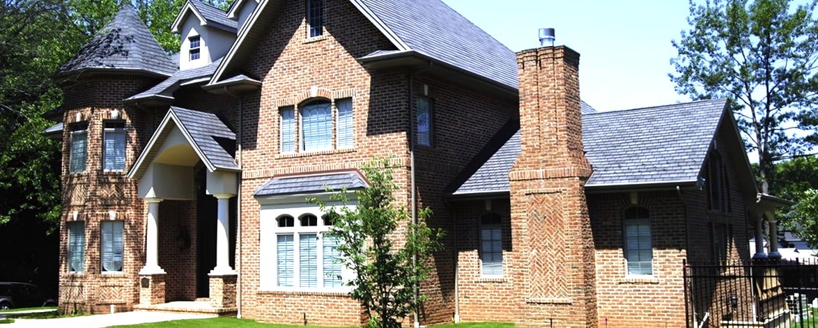 Red brick house with turret, slate roof and herringbone chimney